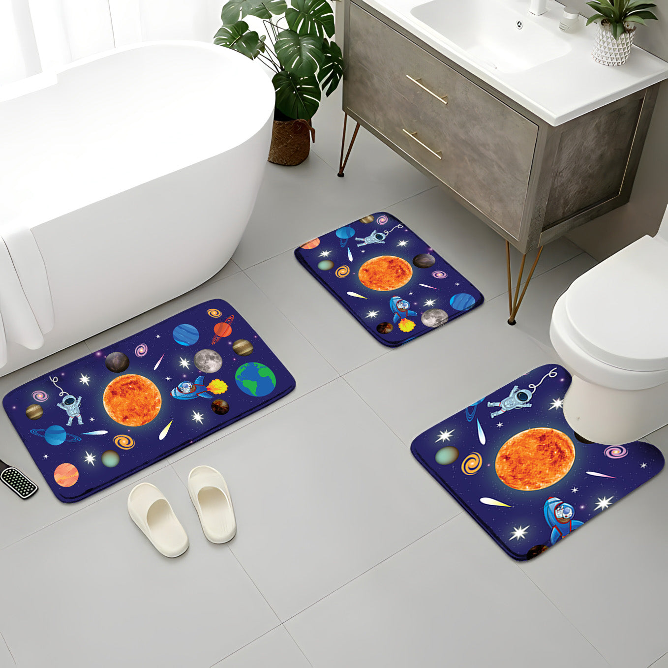 A modern bathroom featuring the Khelo Space-Themed Kids Bath Mat Set, including three anti-slip bath rugs with vibrant astronaut and planet designs. This space-themed bath rug set includes a large bath mat, a sink mat, and a U-shaped toilet mat, providing full coverage for a fun and functional kids' bathroom. Made with soft, cushioned fabric and a non-slip backing, these mats ensure safety, comfort, and durability. Perfect for space-loving kids and parents looking to enhance their child's bathroom decor.