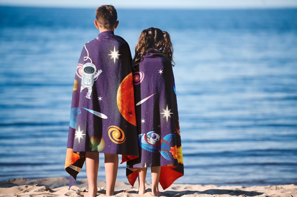 Khelo Space-Themed Organic Cotton Kids Bath Towel is crafted from ultra-soft, high-absorbency organic cotton, featuring a vibrant astronaut and rocket design with planets and stars. This lightweight, quick-drying towel is perfect for bath time, beach days, and poolside fun. Made with premium double-stitched fabric for durability, it withstands frequent washing while maintaining its plush texture.