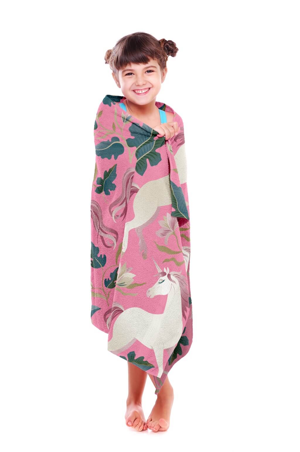 Smiling young girl wrapped in a pink unicorn organic cotton towel, showcasing a charming design with elegant white unicorns, lush floral patterns, and soft pastel tones. This ultra-soft and highly absorbent towel is made from 100% organic cotton, offering breathable comfort and quick-drying properties. Perfect for bath time, beach outings, and poolside fun, this premium-quality towel by Khelo ensures warmth and coziness with every use. Designed to be fade-resistant for up to 500 washes, it’s a long-lasting 